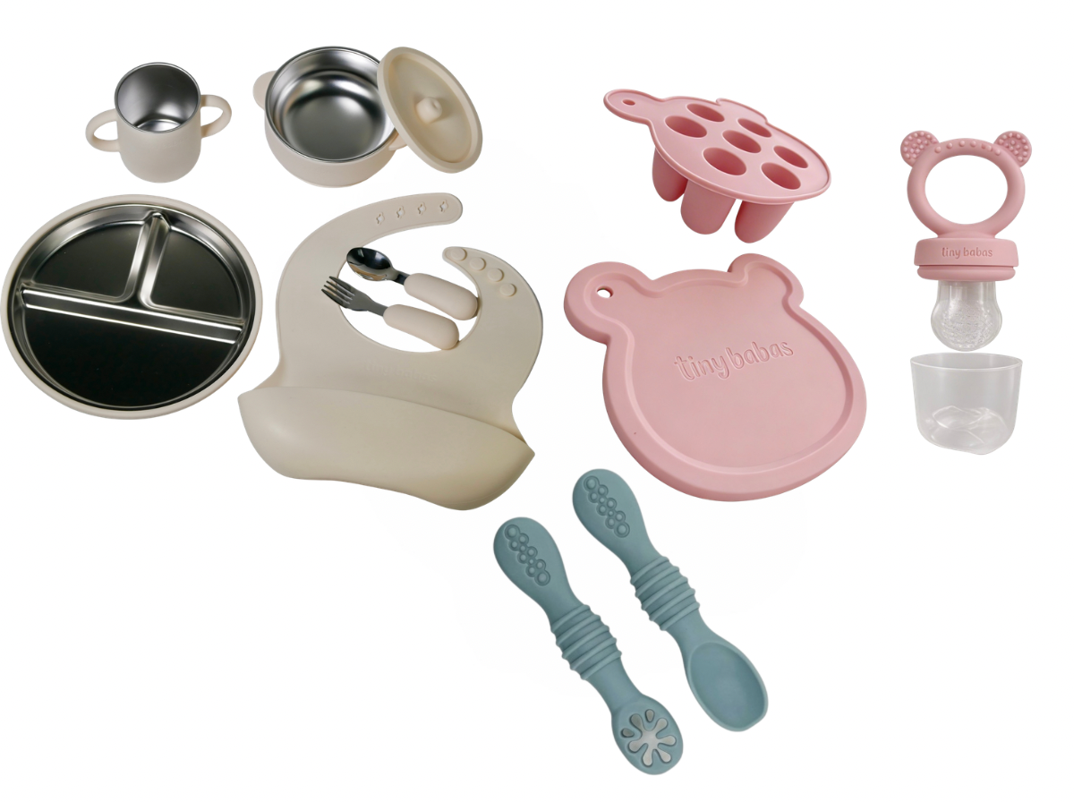 Baby weaning set in cream (2 in 1 stainless steel and silicone bowl with lid, silicone bib, stainless steel cutlery with silicone handle) pink  silicone baby feeder with tray and hygienic lid and blue silicone spoons