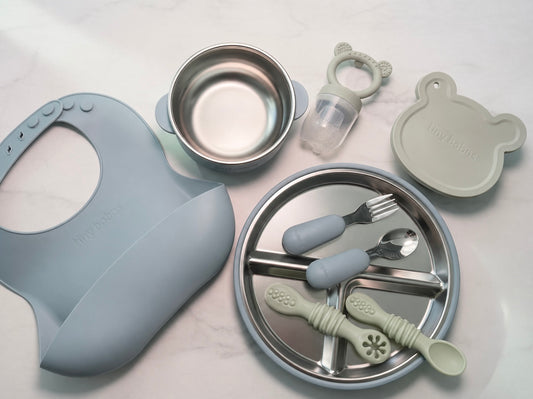 Baby weaning set in blue (2 in 1 stainless steel and silicone bowl with lid, silicone bib, stainless steel cutlery with silicone handle) Light Taupe silicone baby feeder with tray and hygienic lid. 